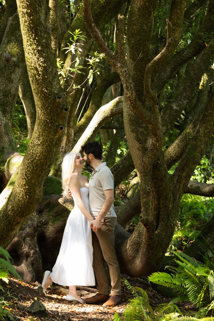 Lenny and Leilani standing close together among mossy trees and ferns